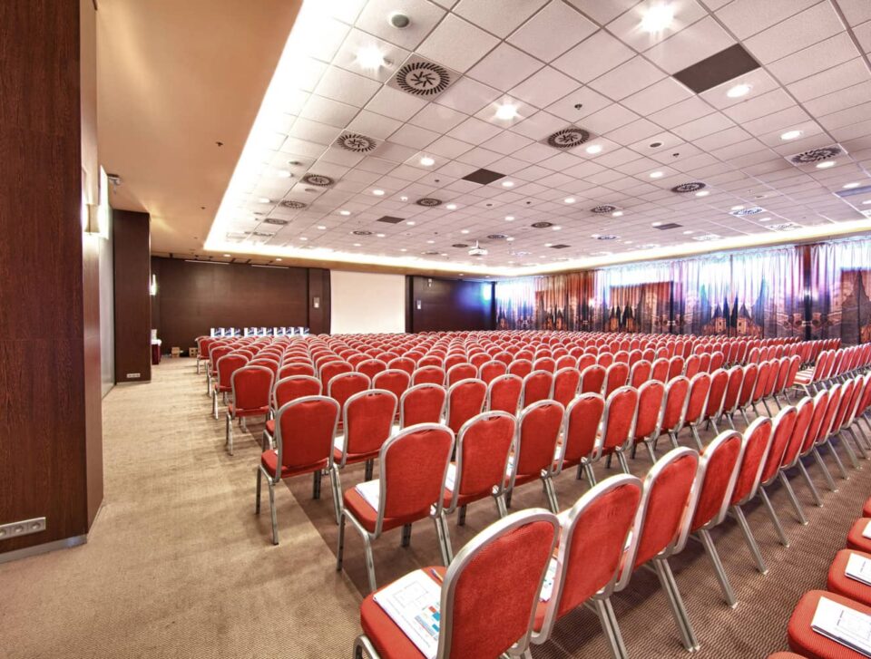 Millennium conference hall with red theatre seating.